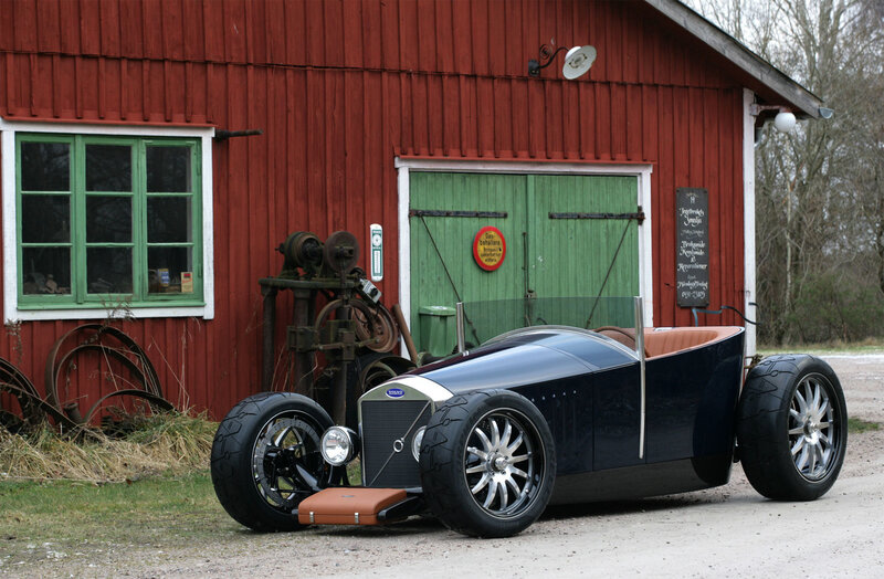 Custom hot rod car in front of barn