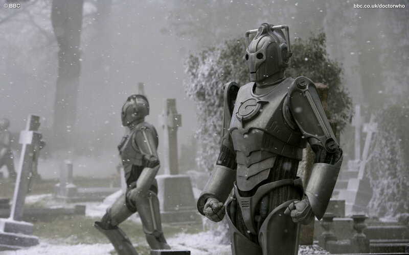 Cybermen in a snowy graveyard