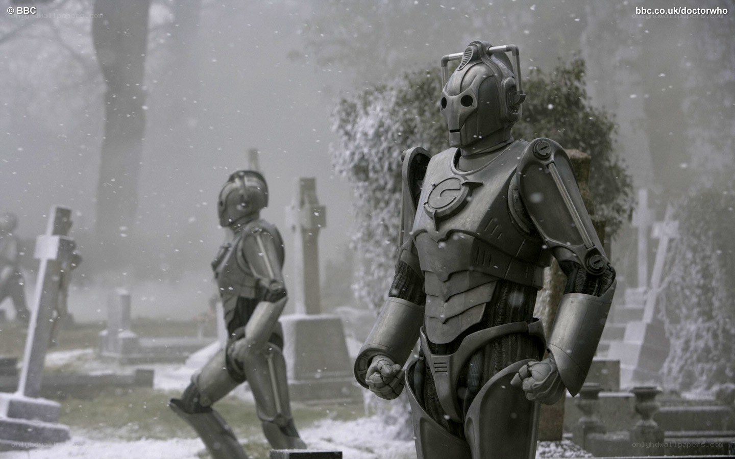 Cybermen in a snowy graveyard