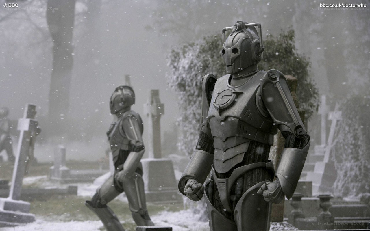 Cybermen in a snowy graveyard