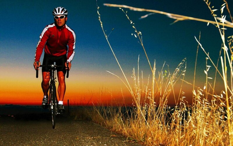 cyclist at sunset on a road