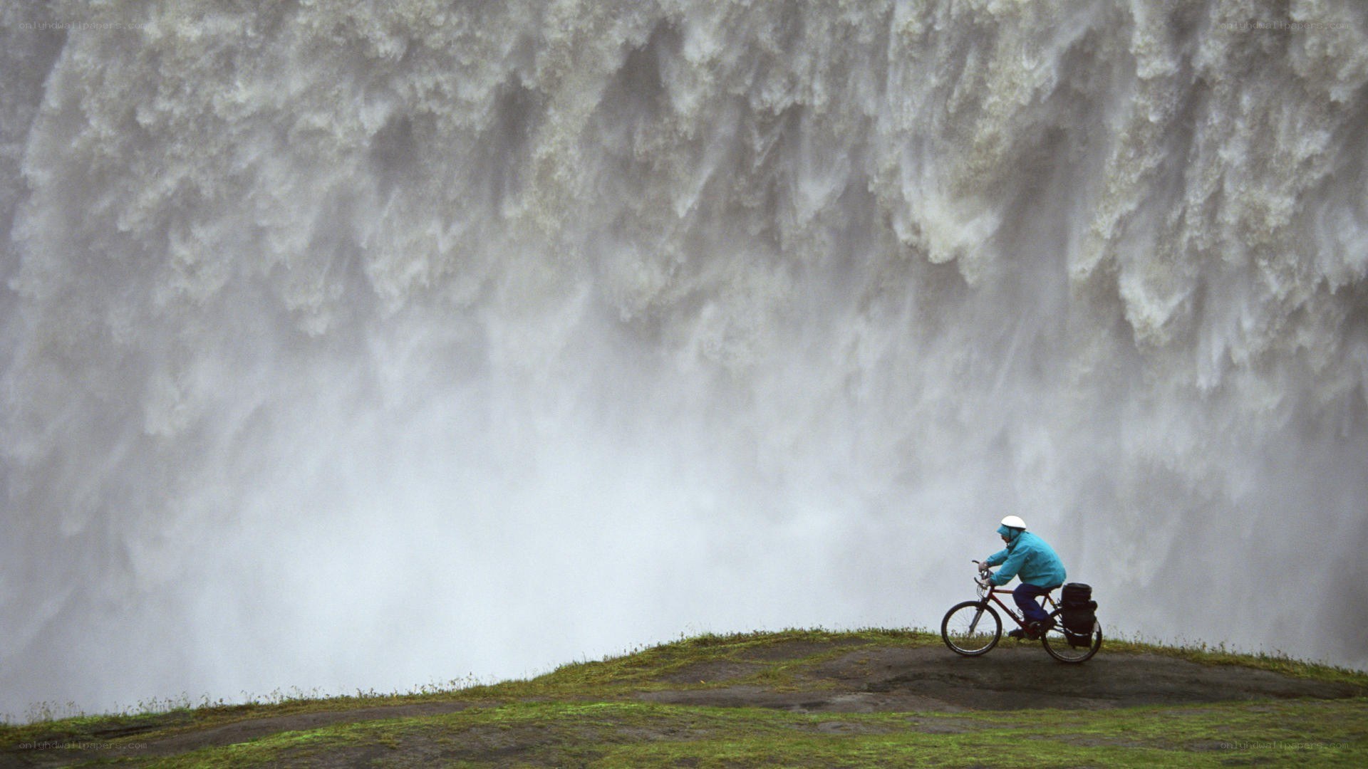 Cyclist near a massive waterfall