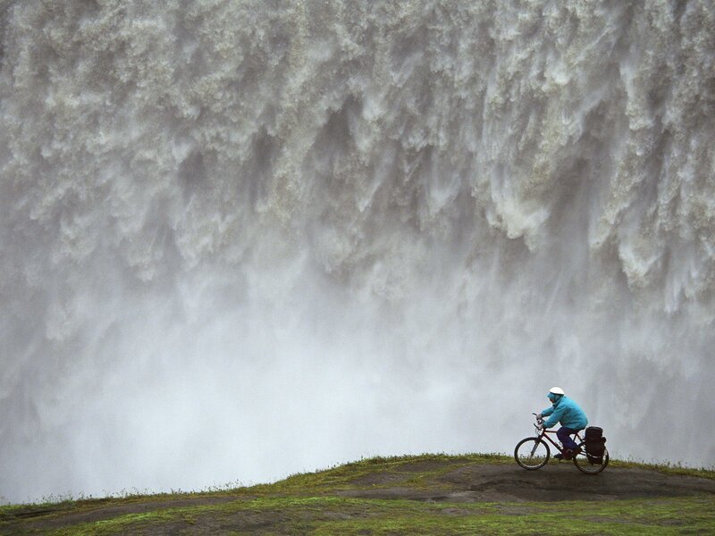 Cyclist near a massive waterfall