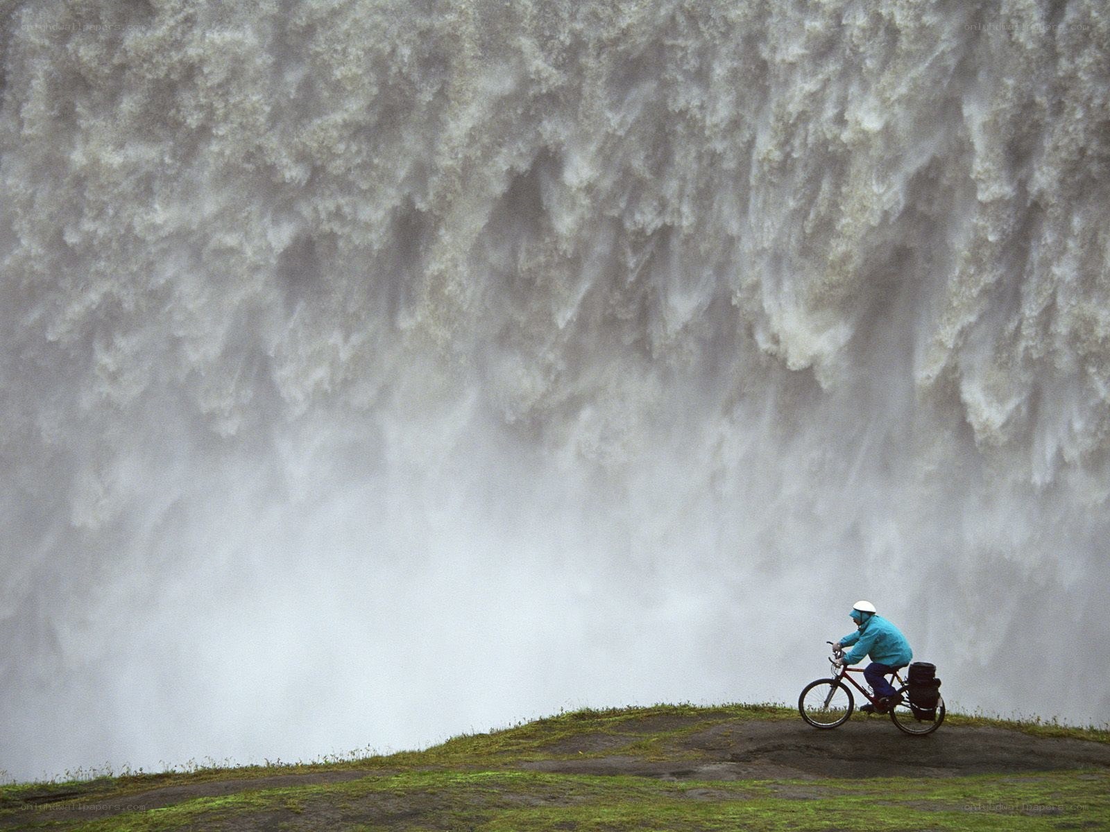 Cyclist near a massive waterfall