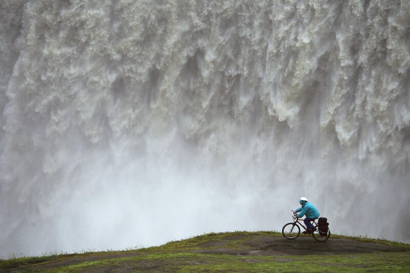 Cyclist near a massive waterfall