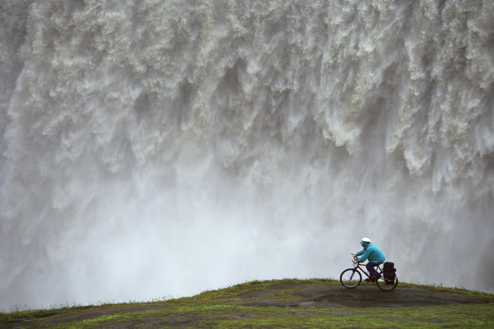 Cyclist near a massive waterfall