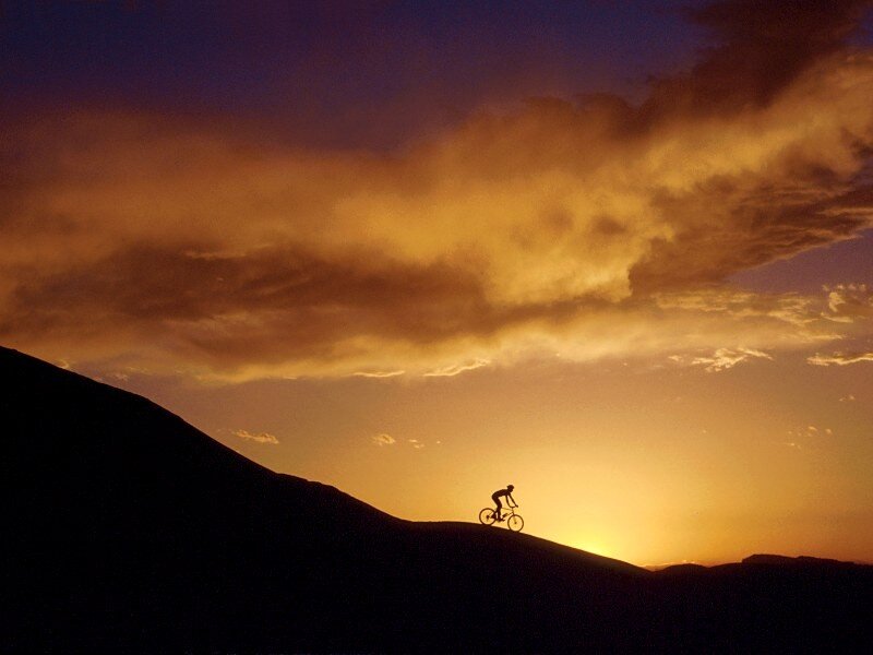 Cyclist on a hill at sunset