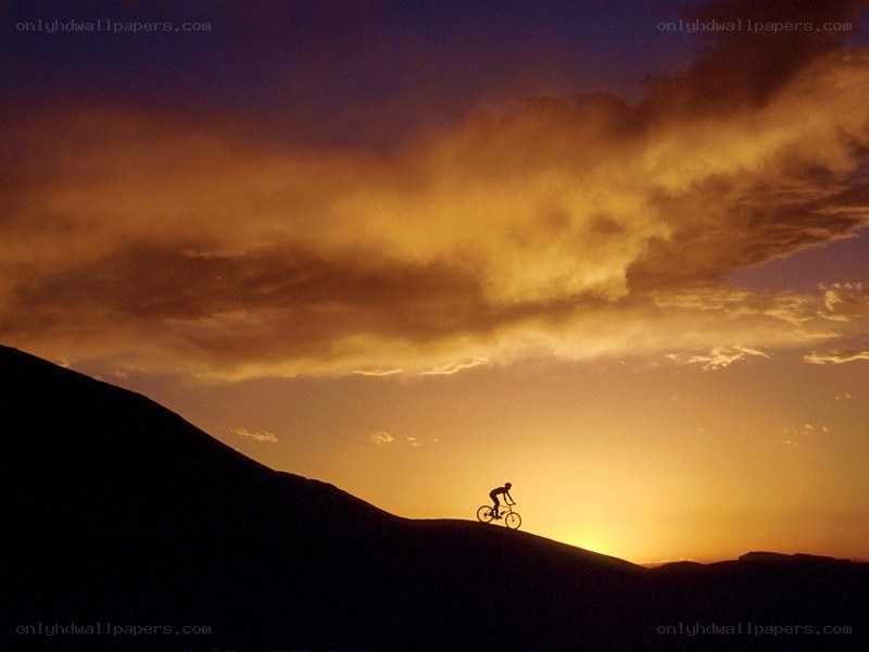 Cyclist on a hill at sunset