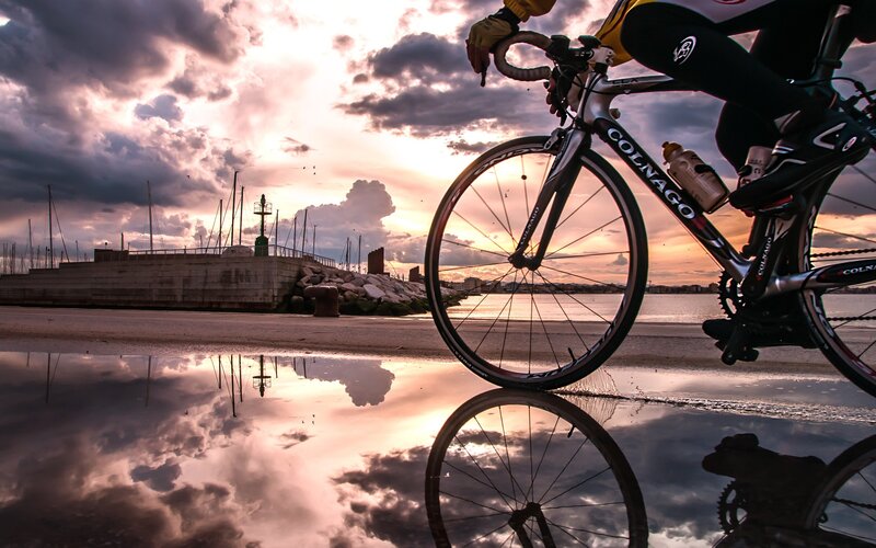Cyclist on Beach at Sunset — Purple, Dramatic