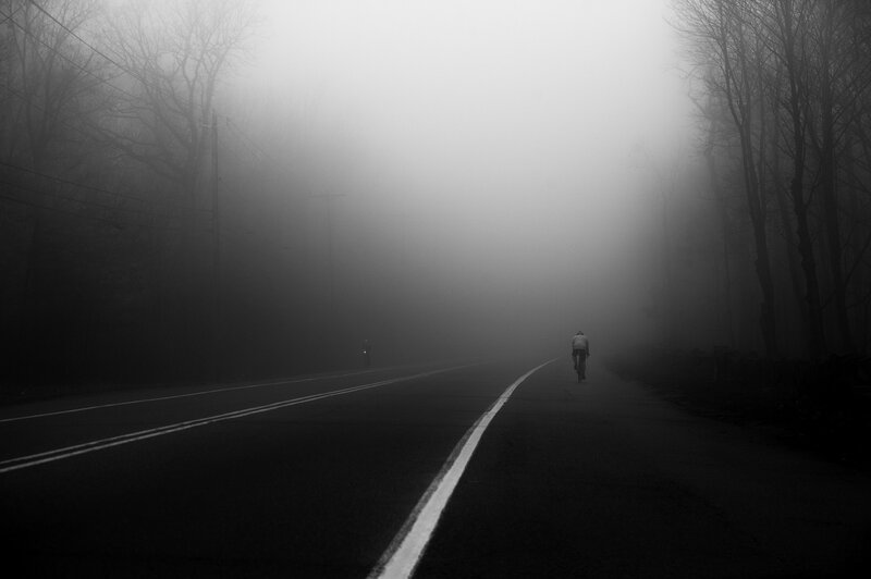 Cyclist on Foggy Road