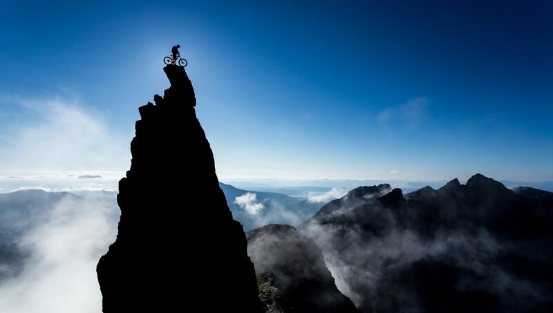 Cyclist on Mountain Peak — Blue