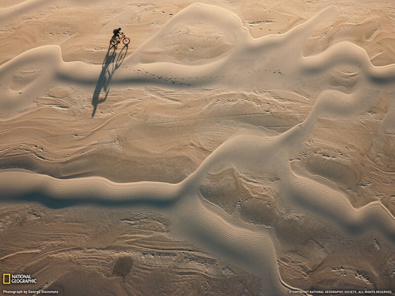 Cyclist on sand dunes