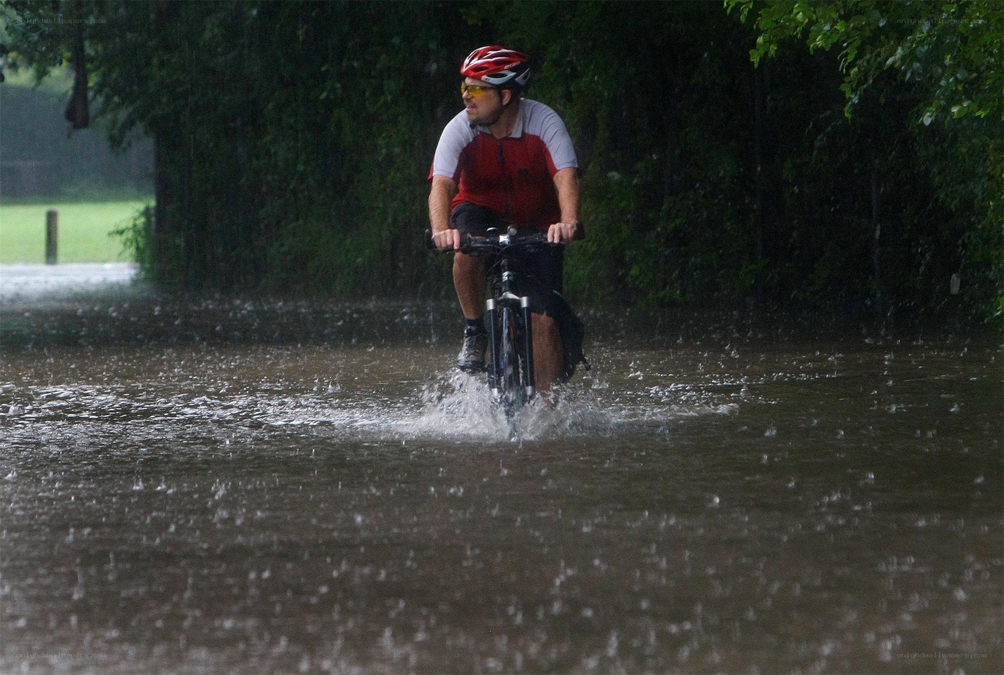 Cyclist rides through floodwaters