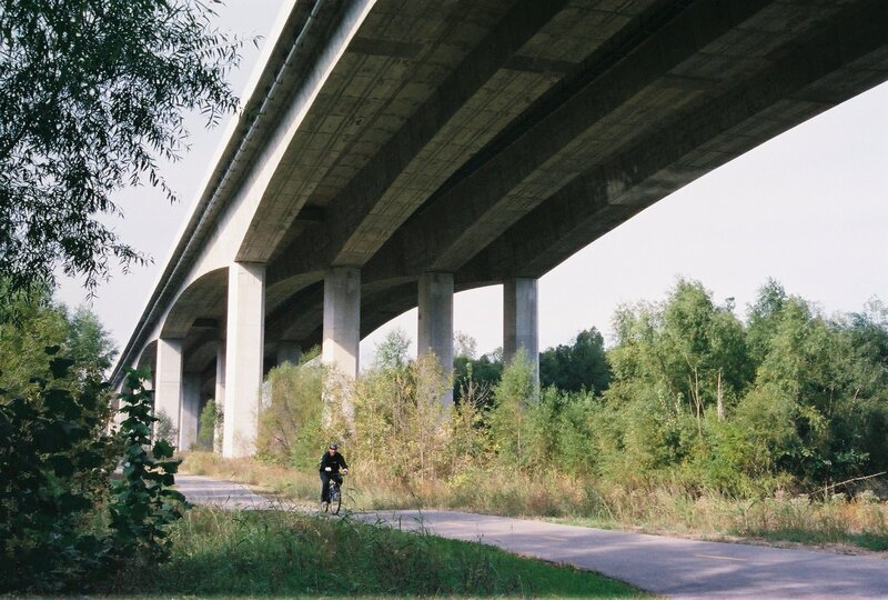 Cyclist under a concrete bridge