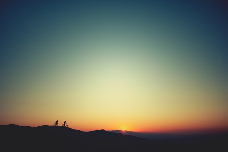Cyclists at sunset on a hill