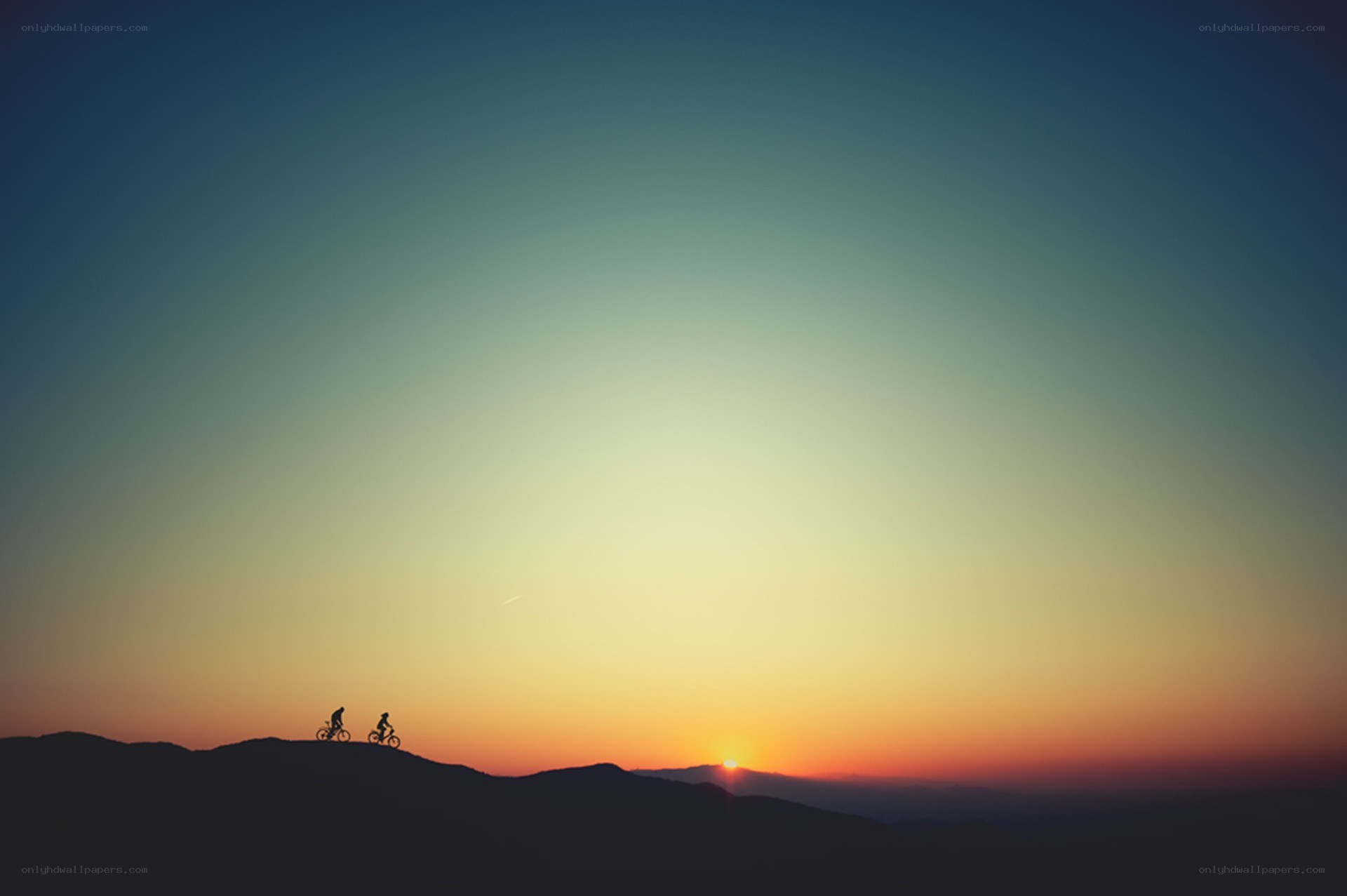 Cyclists at sunset on a hill