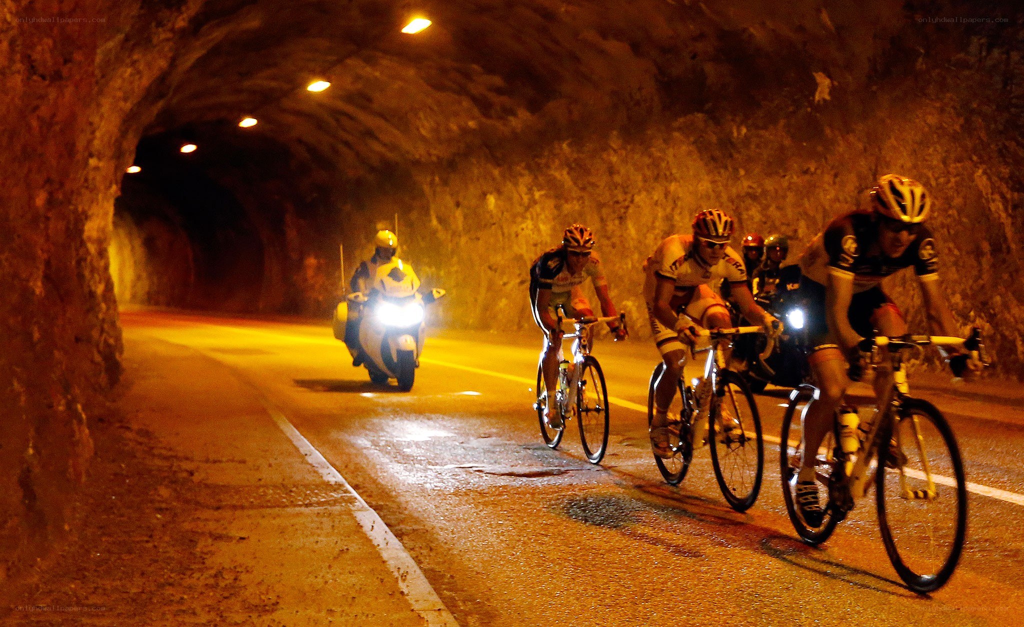Cyclists in a tunnel at night