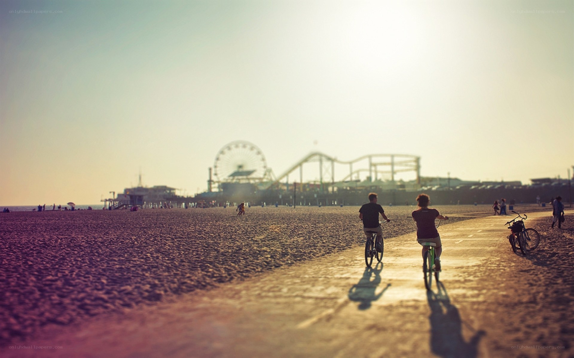 Cyclists on the beach at sunset
