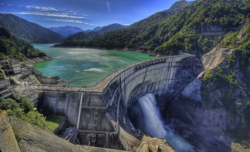 Dam with waterfall in mountain valley