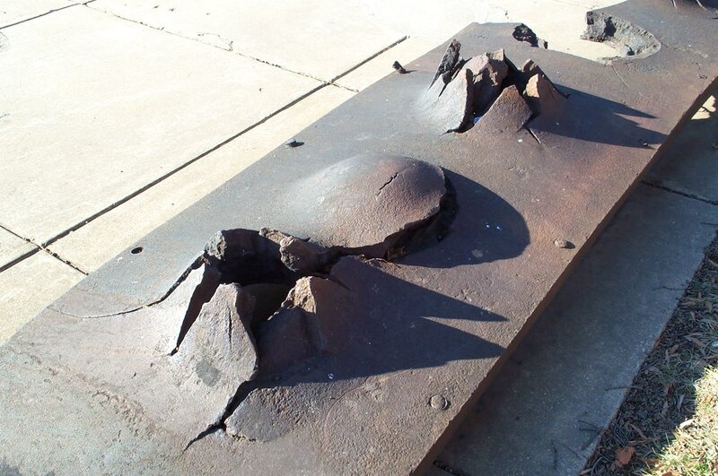 damaged metal plate on sidewalk