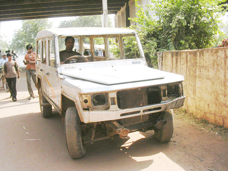 Damaged white jeep under bridge