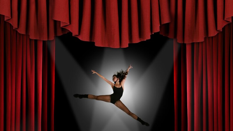 Dancer on stage under spotlight