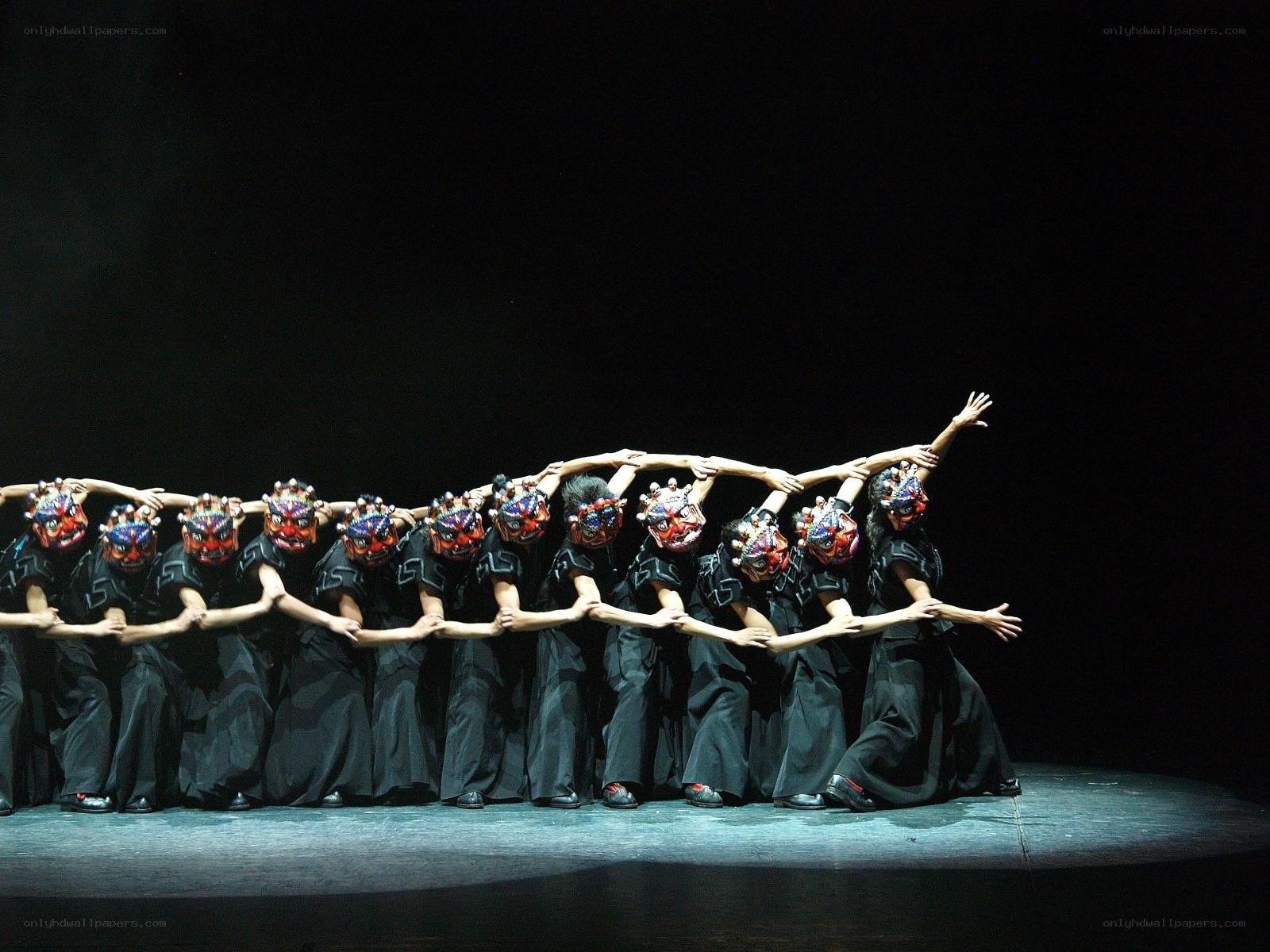 Dancers in masks on stage