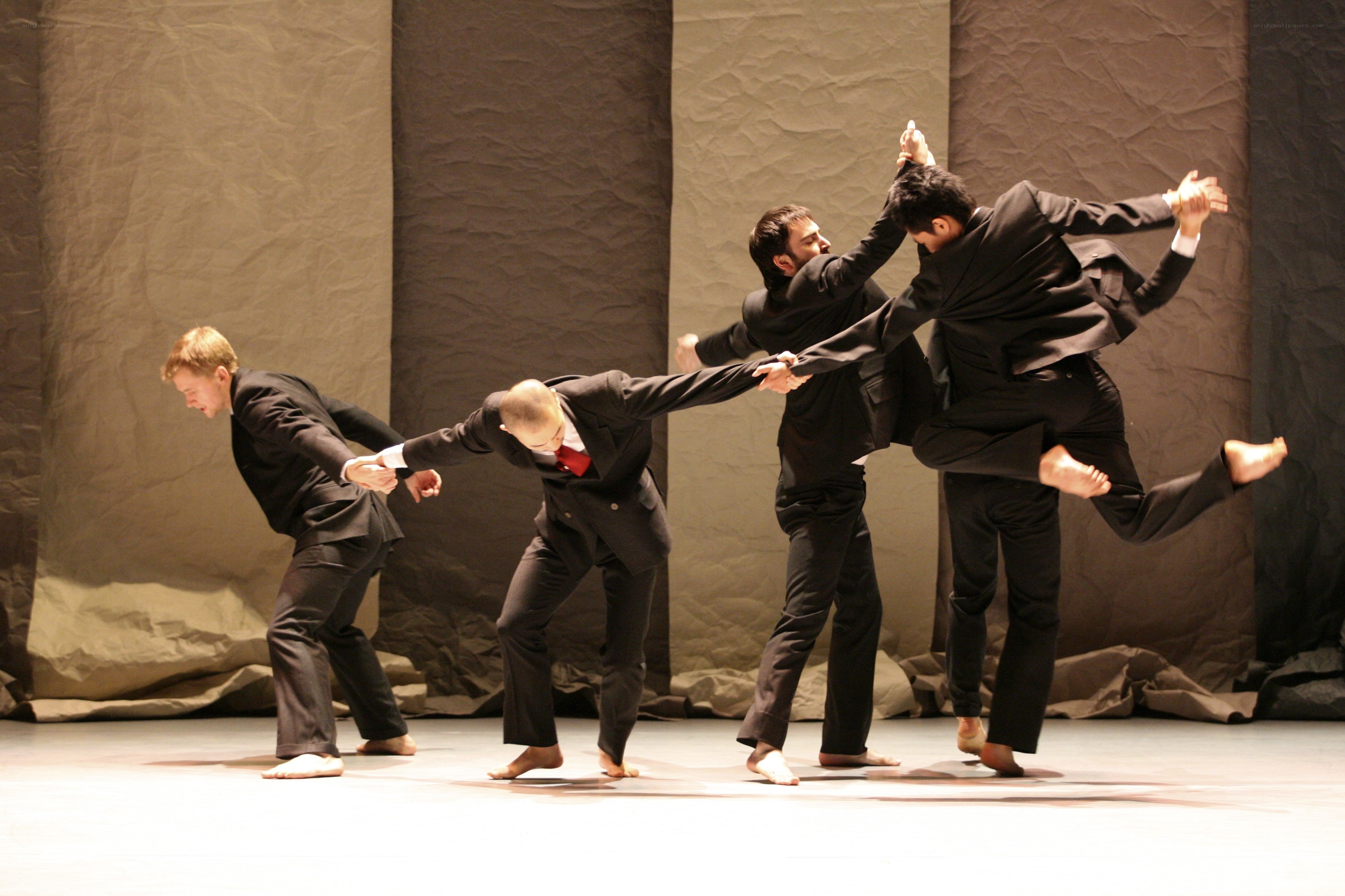 Dancers in suits performing on stage