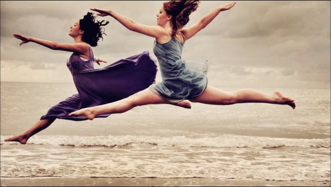 Dancers leaping on the beach
