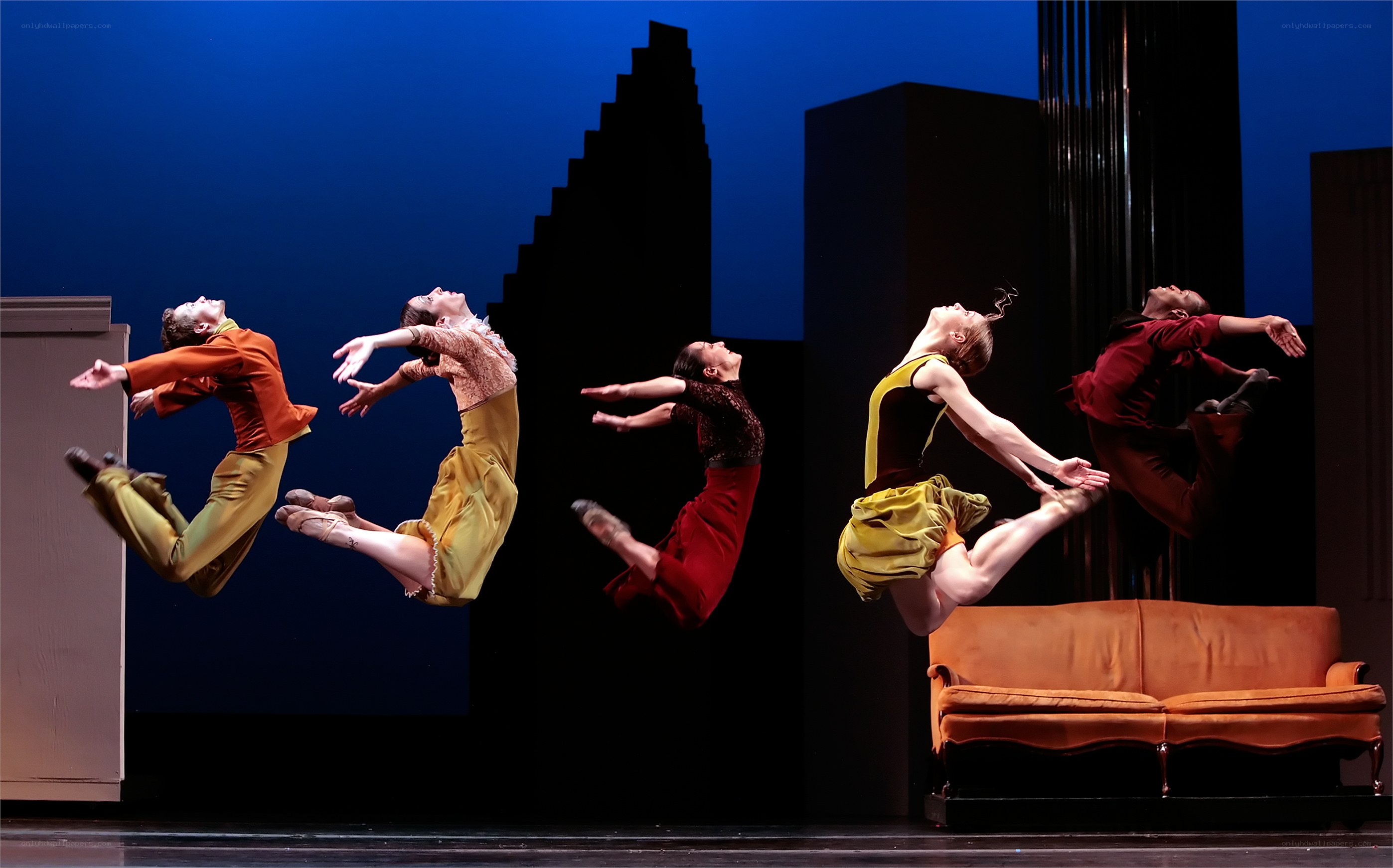 Dancers mid-jump on stage