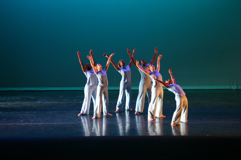 Dancers on stage with raised arms