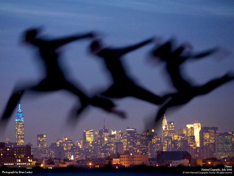 Dancers silhouetted against NYC skyline