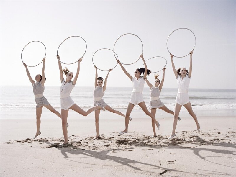 Dancers with hoops on beach