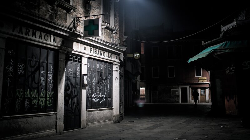 Dark alley with pharmacy at night