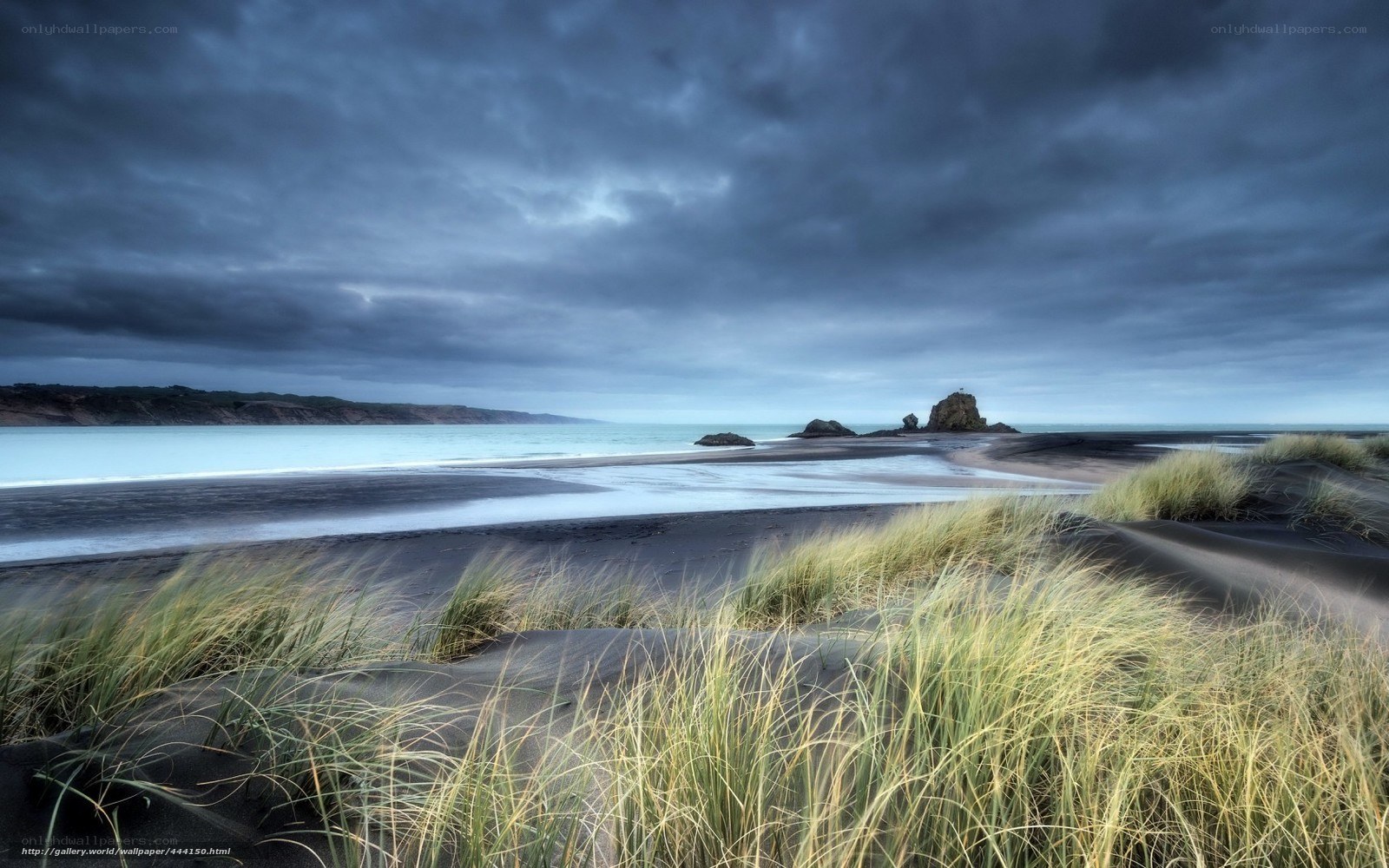 Dark beach with dunes and sea