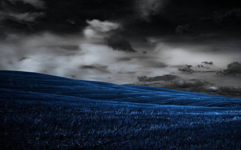 Dark blue field under stormy sky