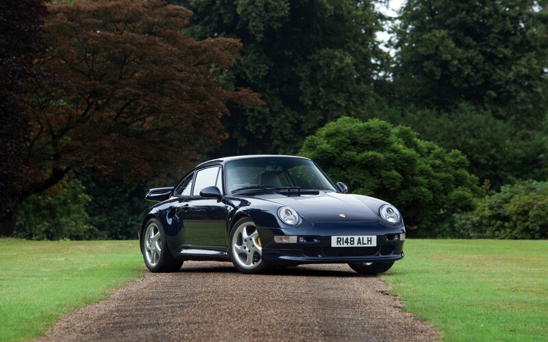 Dark blue Porsche 911 on gravel path