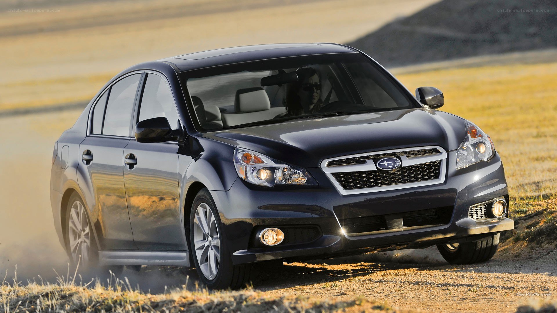 dark blue sedan on dirt road