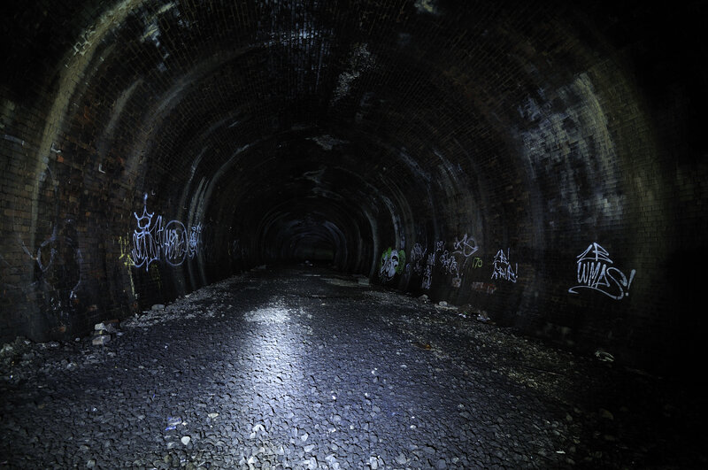 dark brick tunnel with graffiti