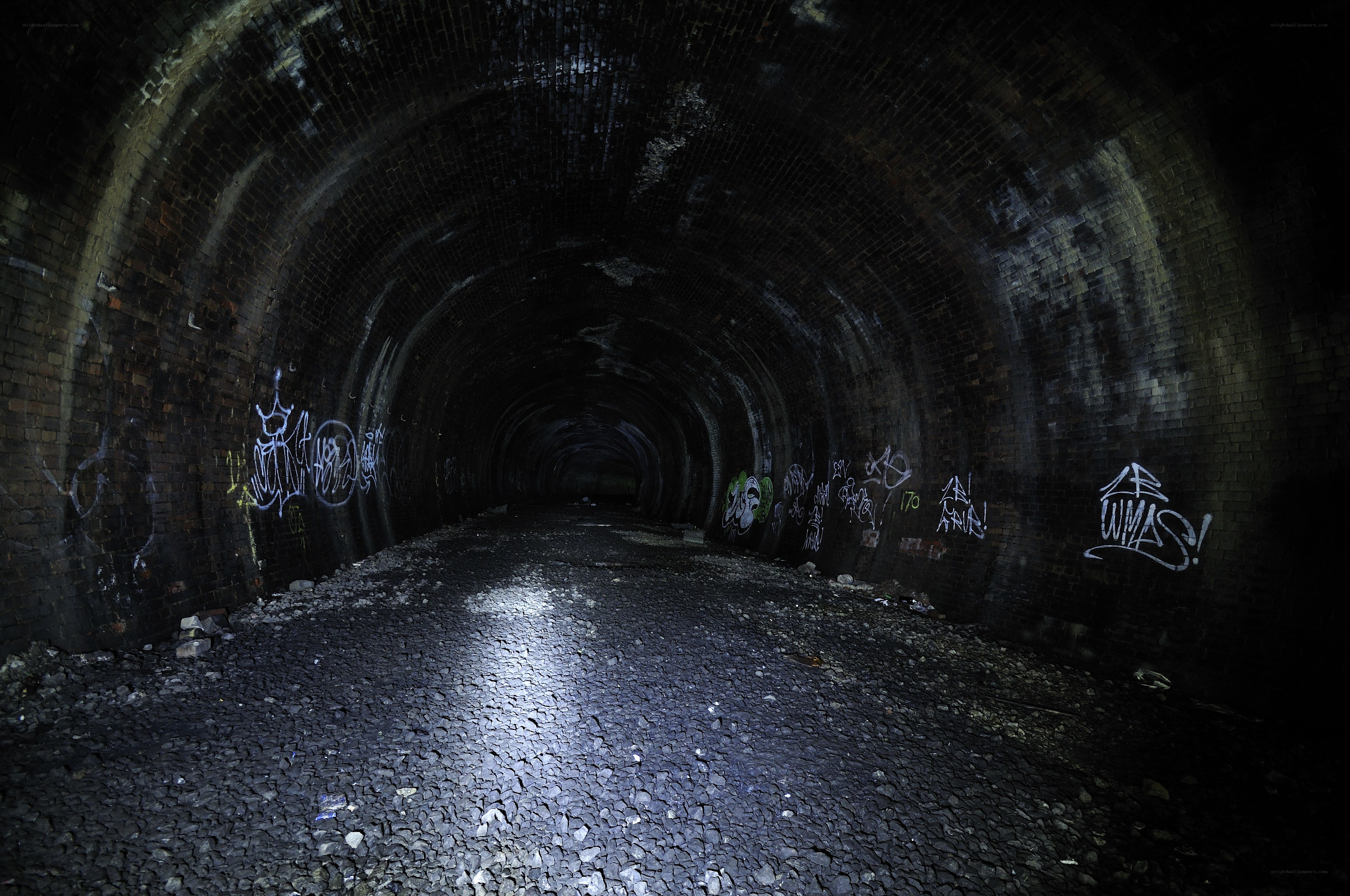 dark brick tunnel with graffiti