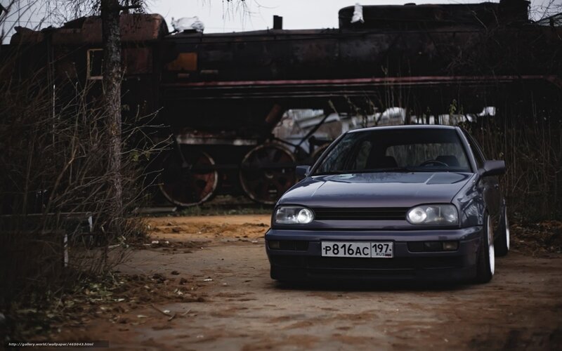 Dark car in front of old train