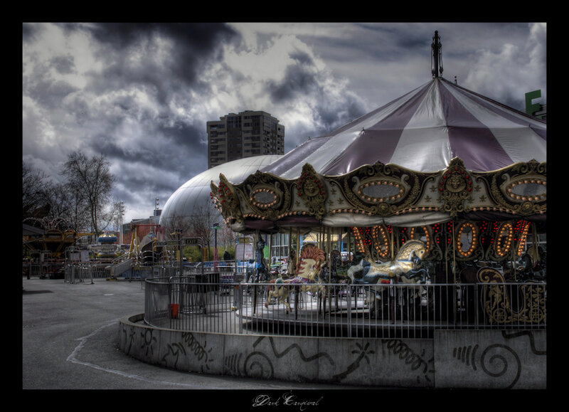 Dark carousel under stormy sky