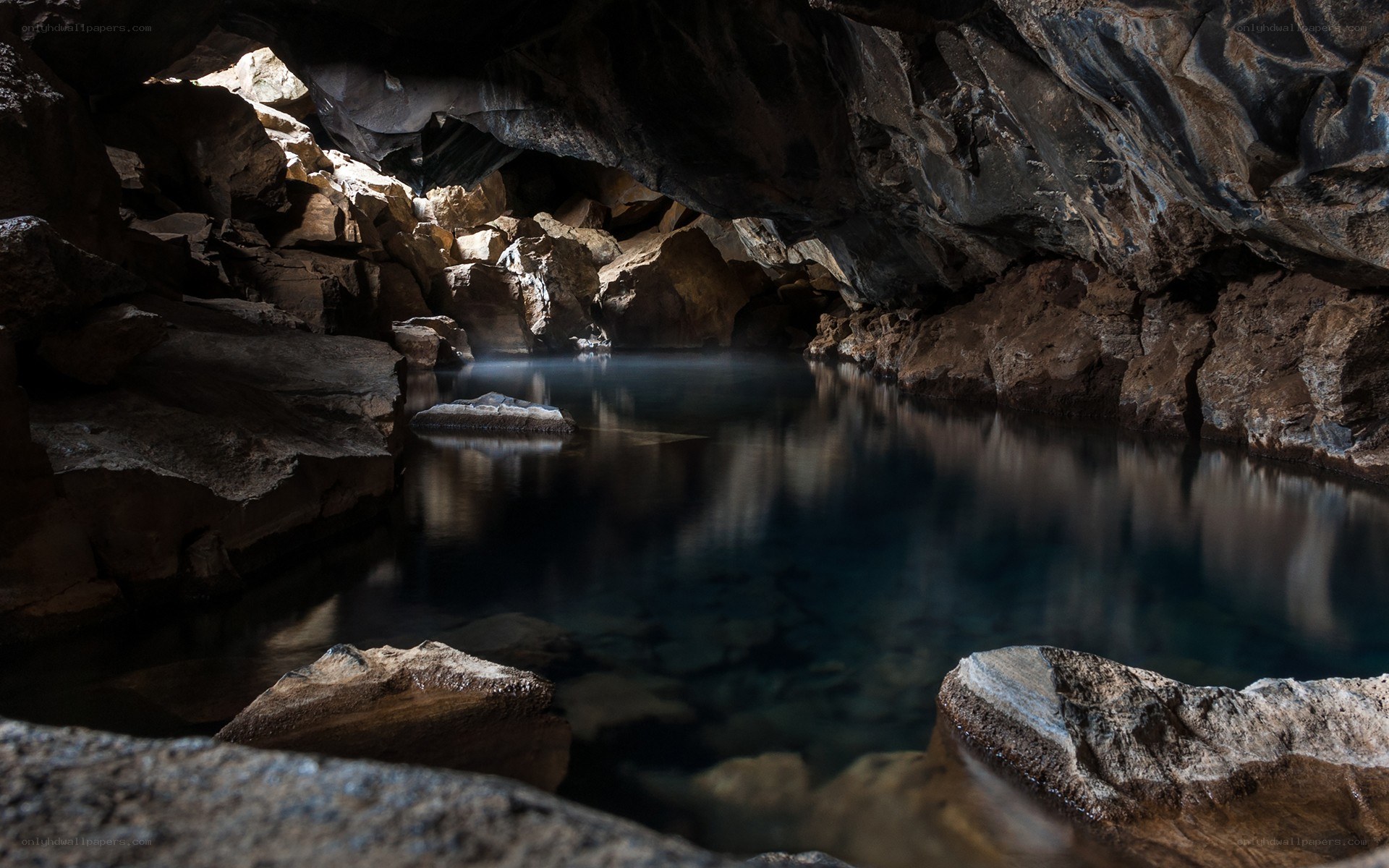 Dark cave with blue water pool