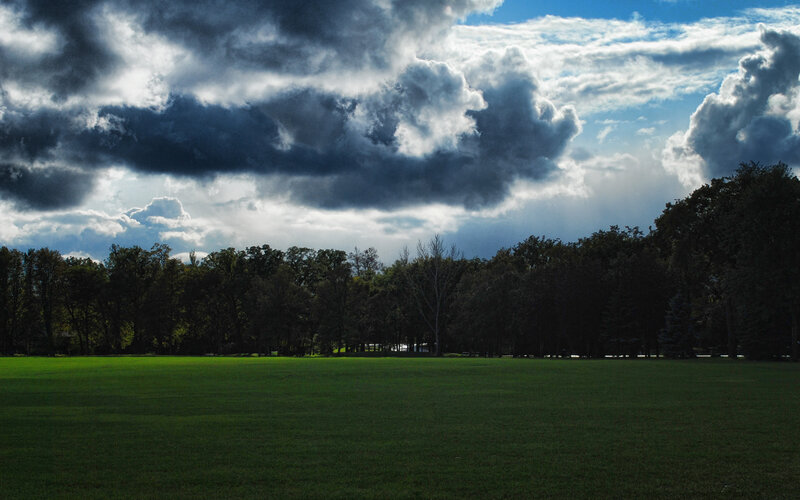 Dark clouds over a green field