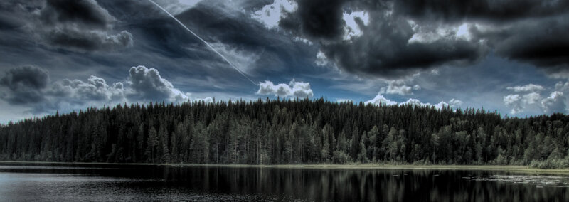 Dark clouds over forest lake
