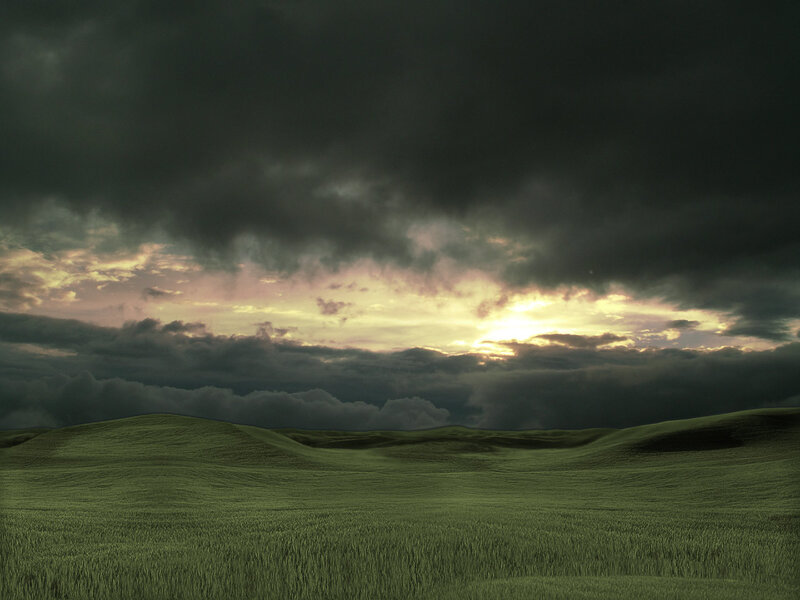 Dark clouds over green hills
