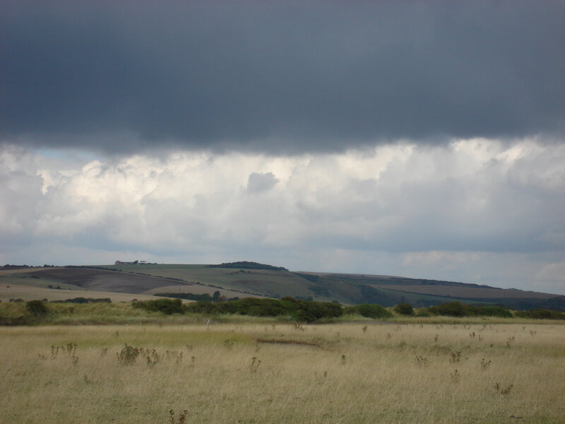 Dark clouds over rolling hills