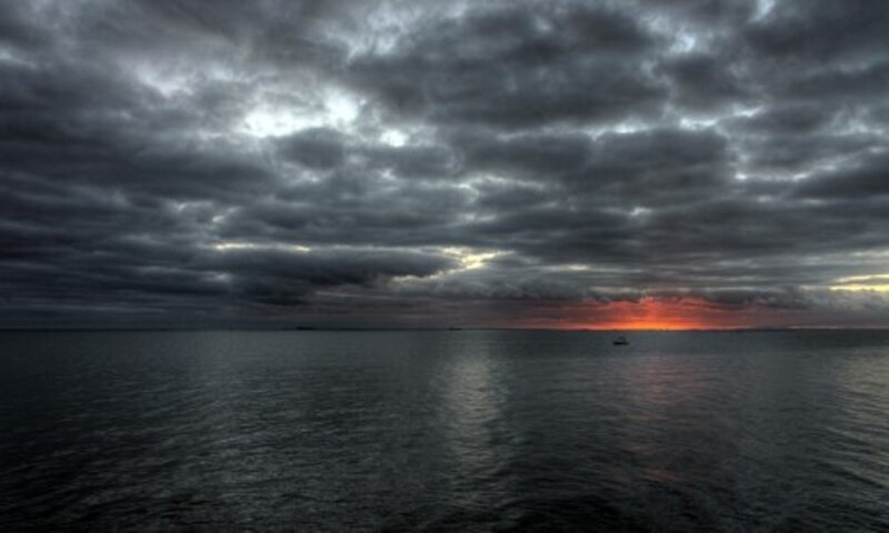 Dark clouds over the sea at sunset