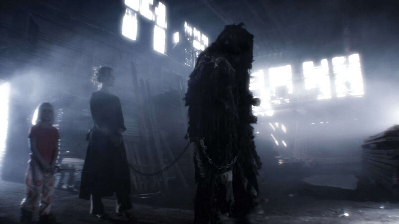 Dark figure with chained captives