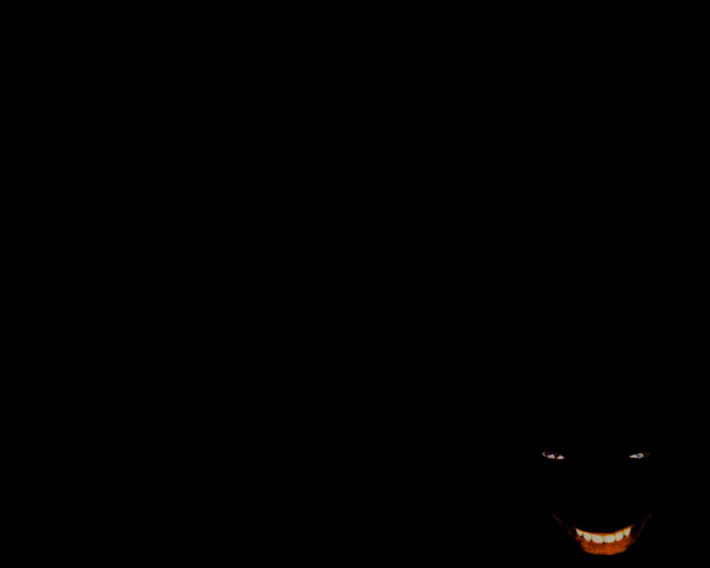 dark figure with glowing eyes and smile